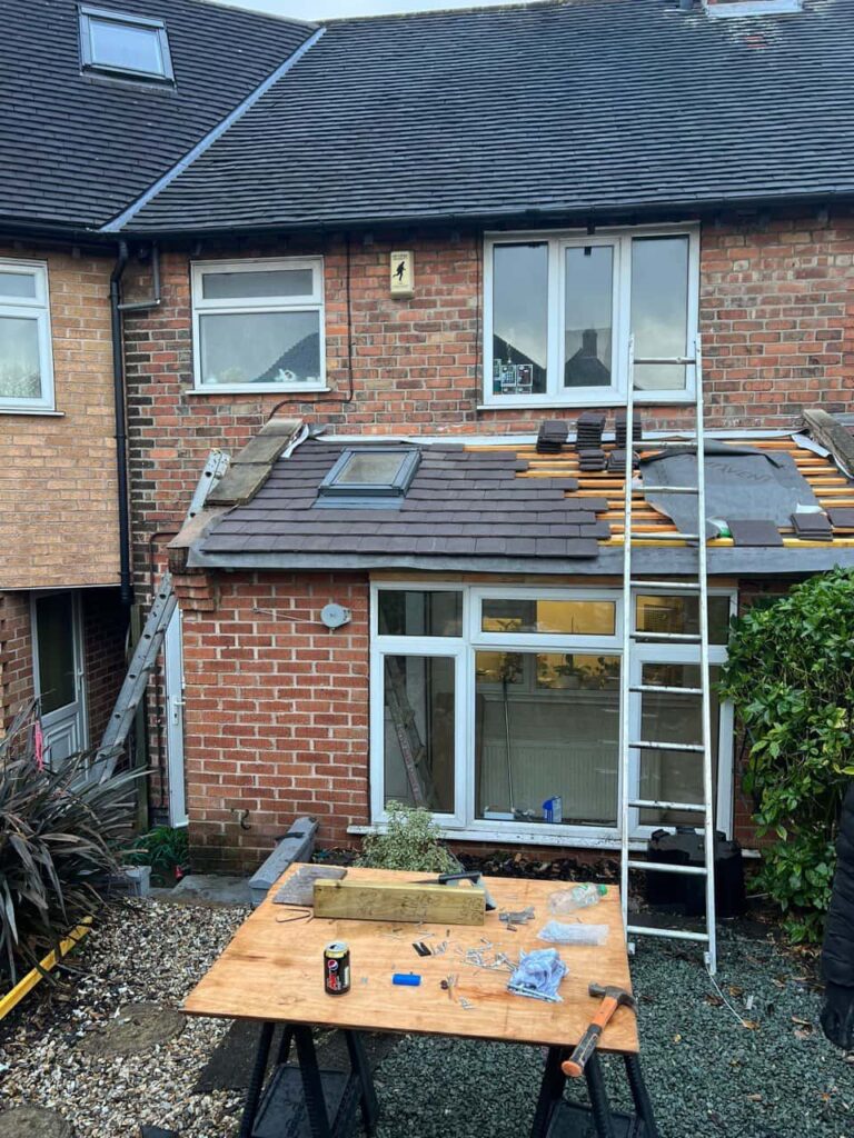 This is a photo of a roof extension that is having new roof tiles installed. This is a photo taken from the roof ridge looking down a tiled pitched roof on to a flat roof. Works carried out by North Hykeham Roofing Repairs