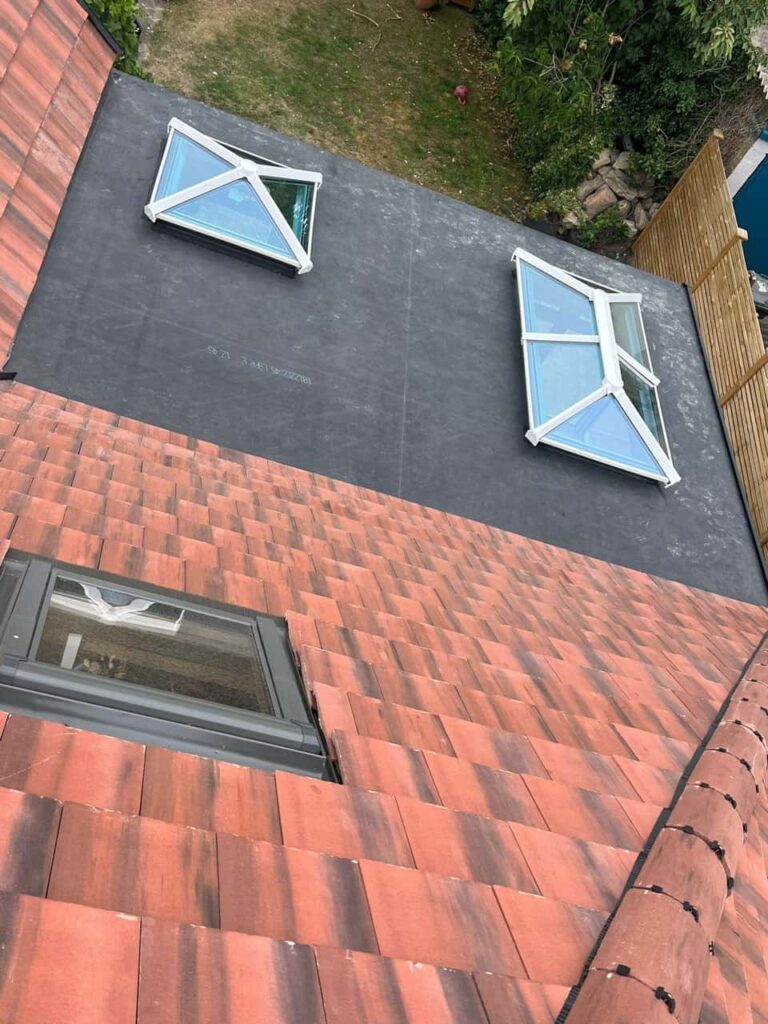 This is a photo taken from the roof ridge looking down a tiled pitched roof on to a flat roof. Works carried out by North Hykeham Roofing Repairs